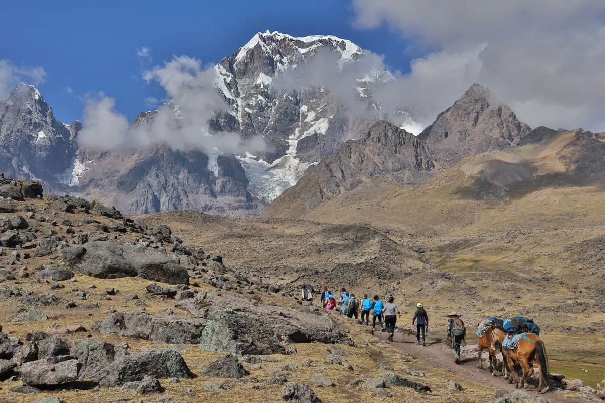 Hikers on the Ausangate Trek in Peru walking through the high Andes near Sibinacocha Lake, one of the best multi-day hiking adventures in South America.